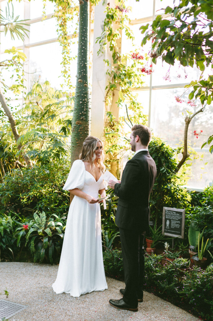 Bride reading her vows to groom during greenhouse elopement ceremony