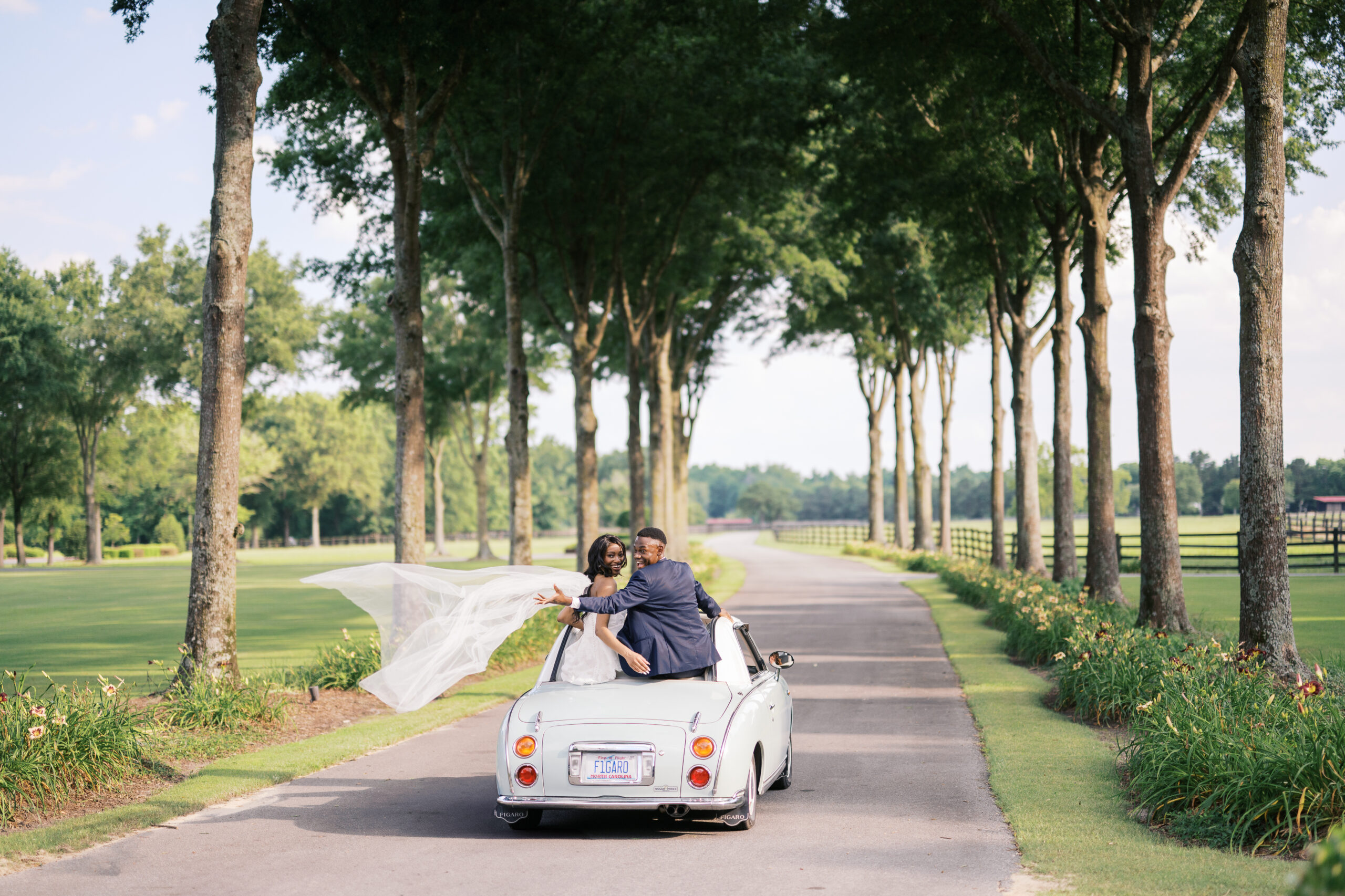 Bride and Groom on vintage wedding getaway car at Britton Manor