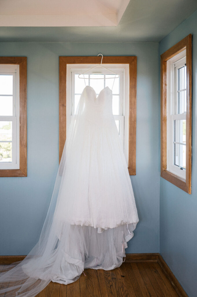 wedding dress hanging at the window