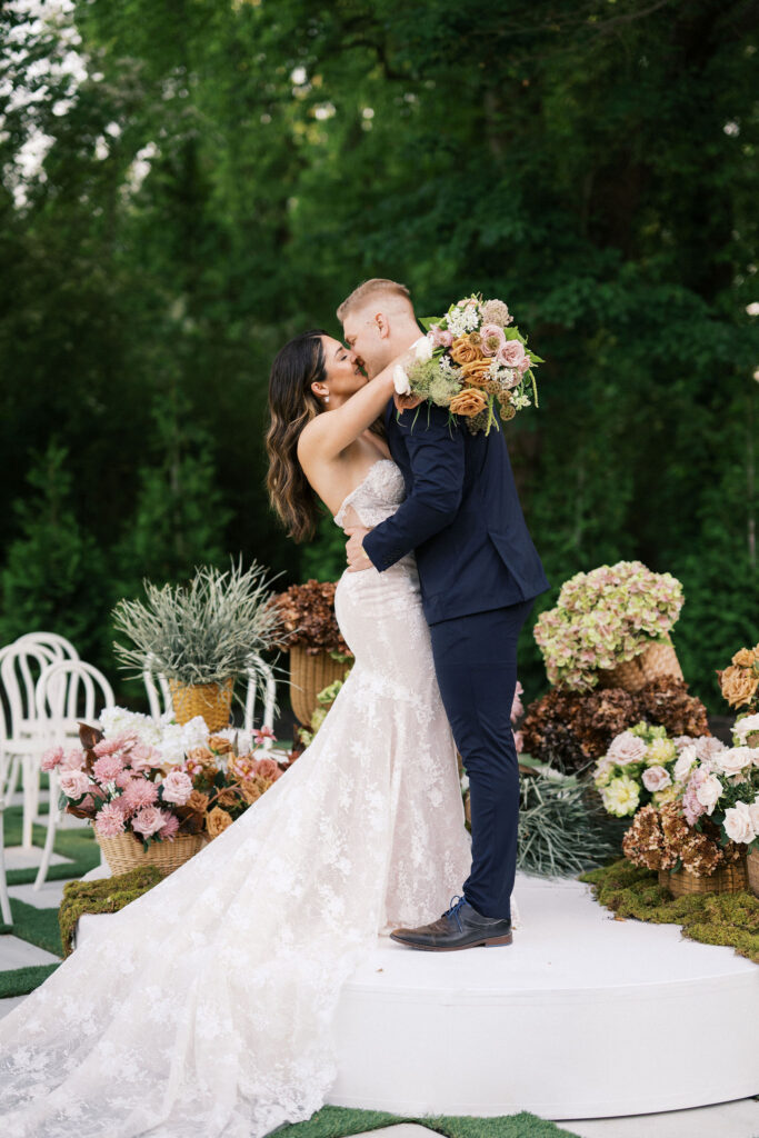 bride and groom kissing at the outdoor ceremony space at greenhouse at arrows farm