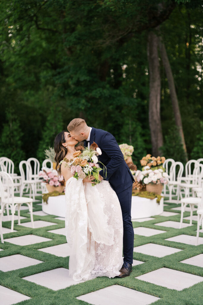 bride and groom kissing at the outdoor ceremony space at greenhouse at arrows farm