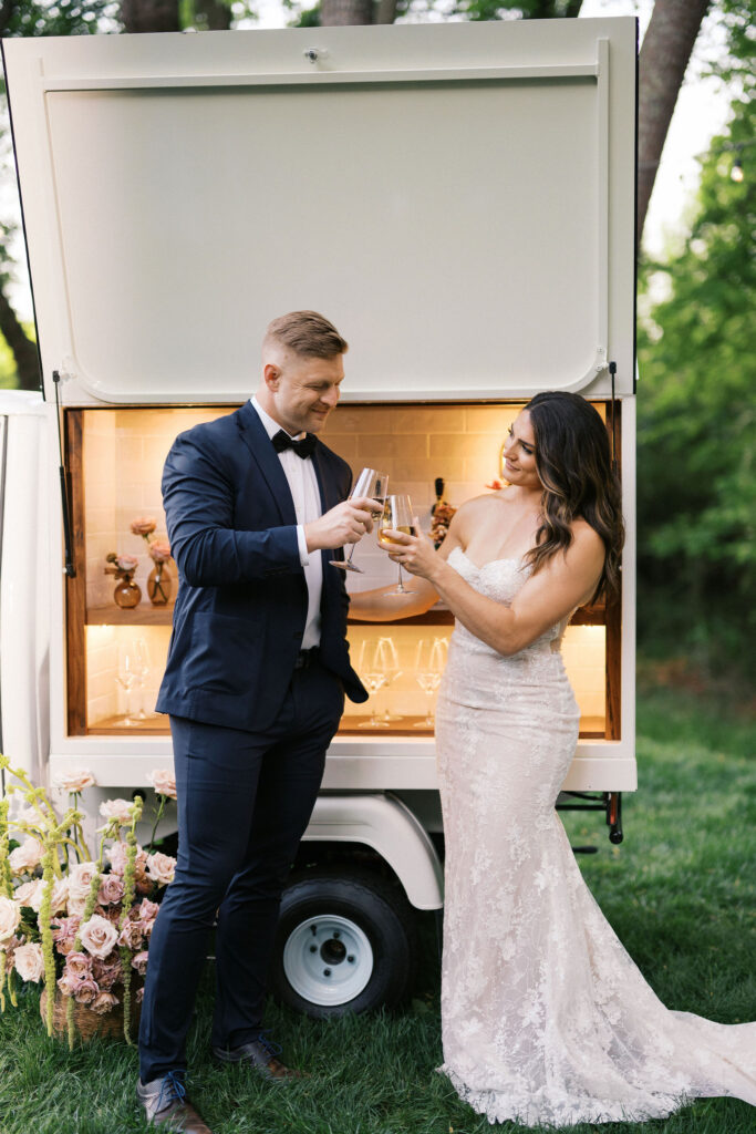 bride and groom celebrating next to a cute beverage cart