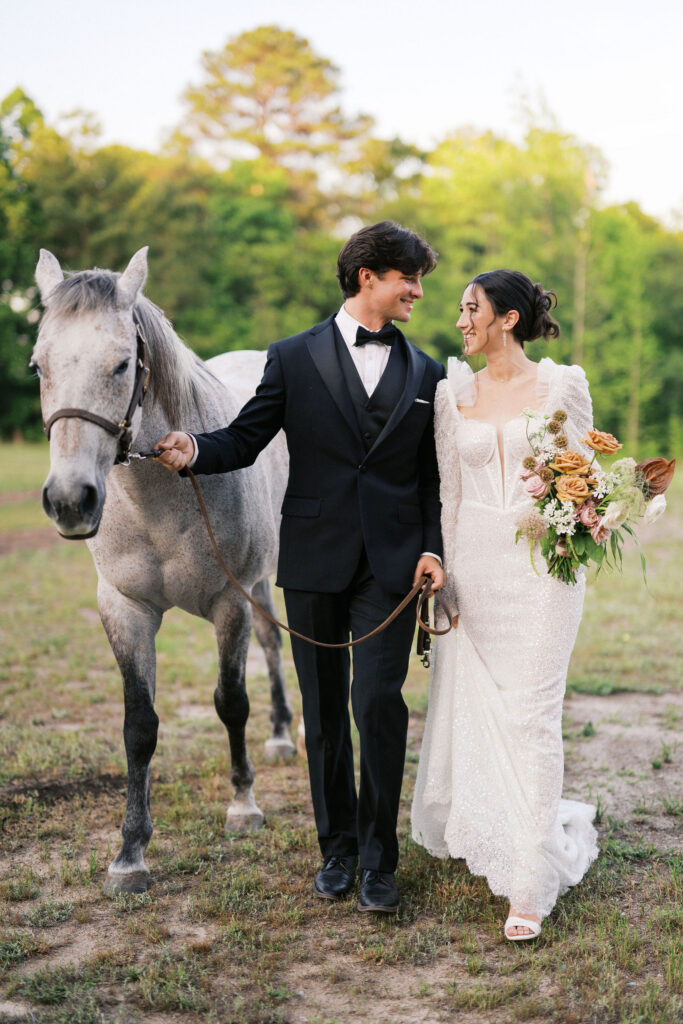 wedding couple walking a horse at the greenhouse at arrows farm