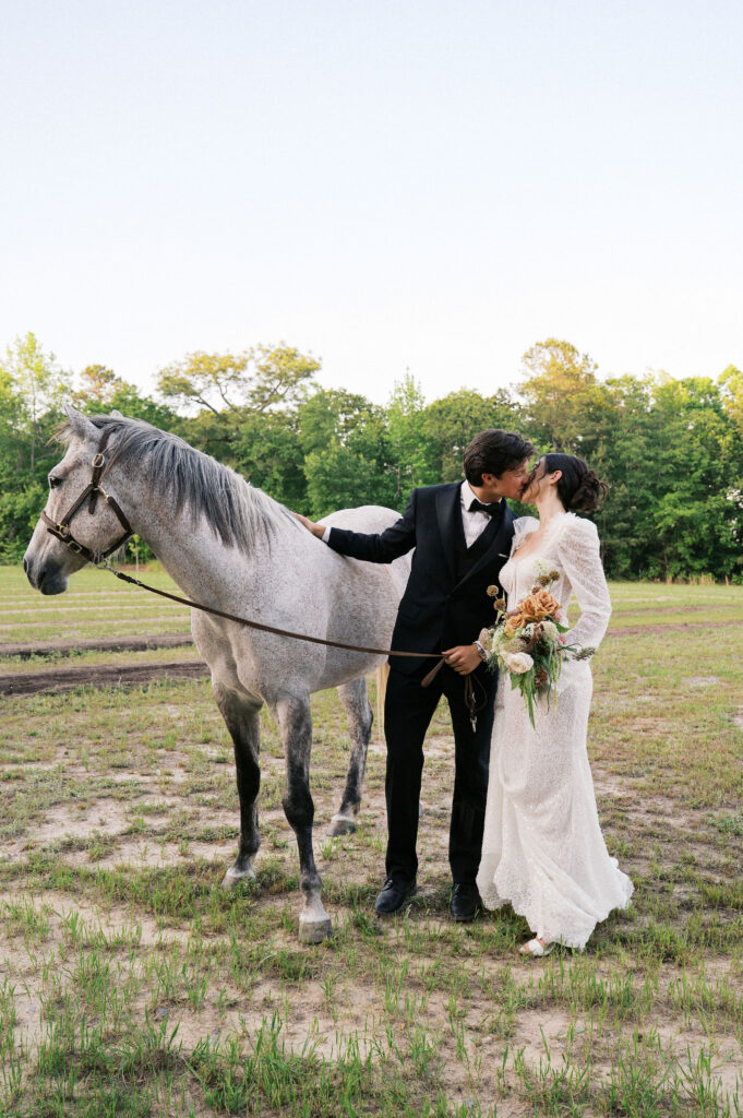 wedding couple walking a horse at the greenhouse at arrows farm