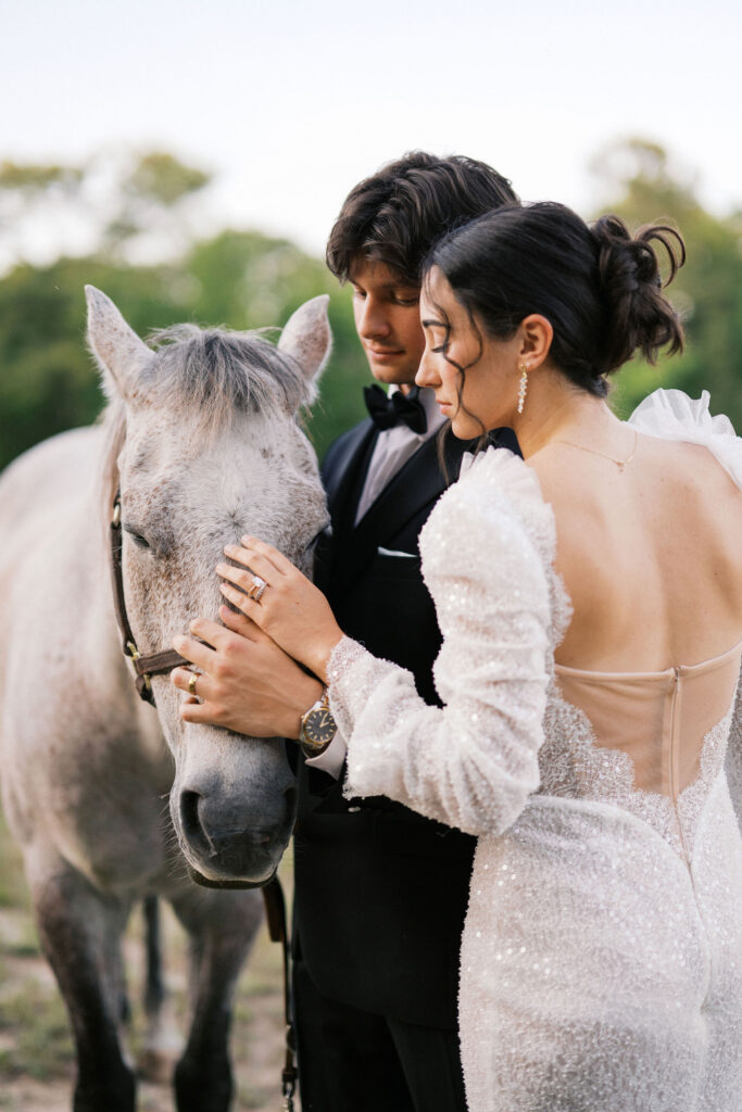 wedding couple walking a horse at the greenhouse at arrows farm