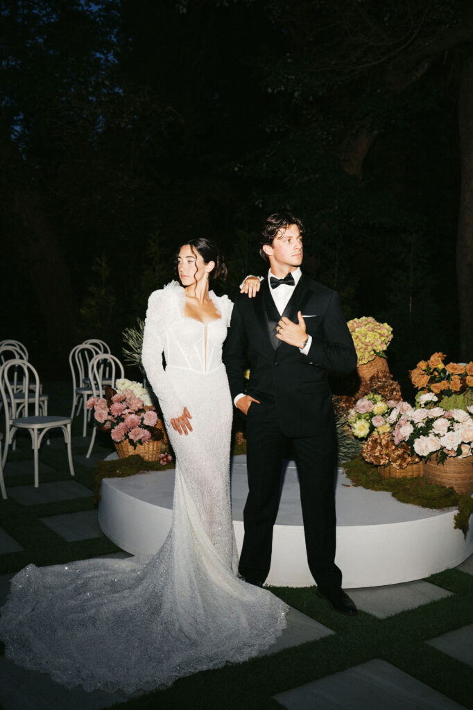 editorial style flash photos of bride and groom kissing at the outdoor ceremony space at greenhouse at arrows farm