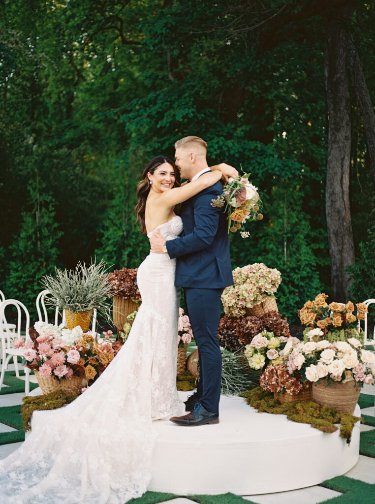 bride and groom posing at the outdoor ceremony space at greenhouse at arrows farm